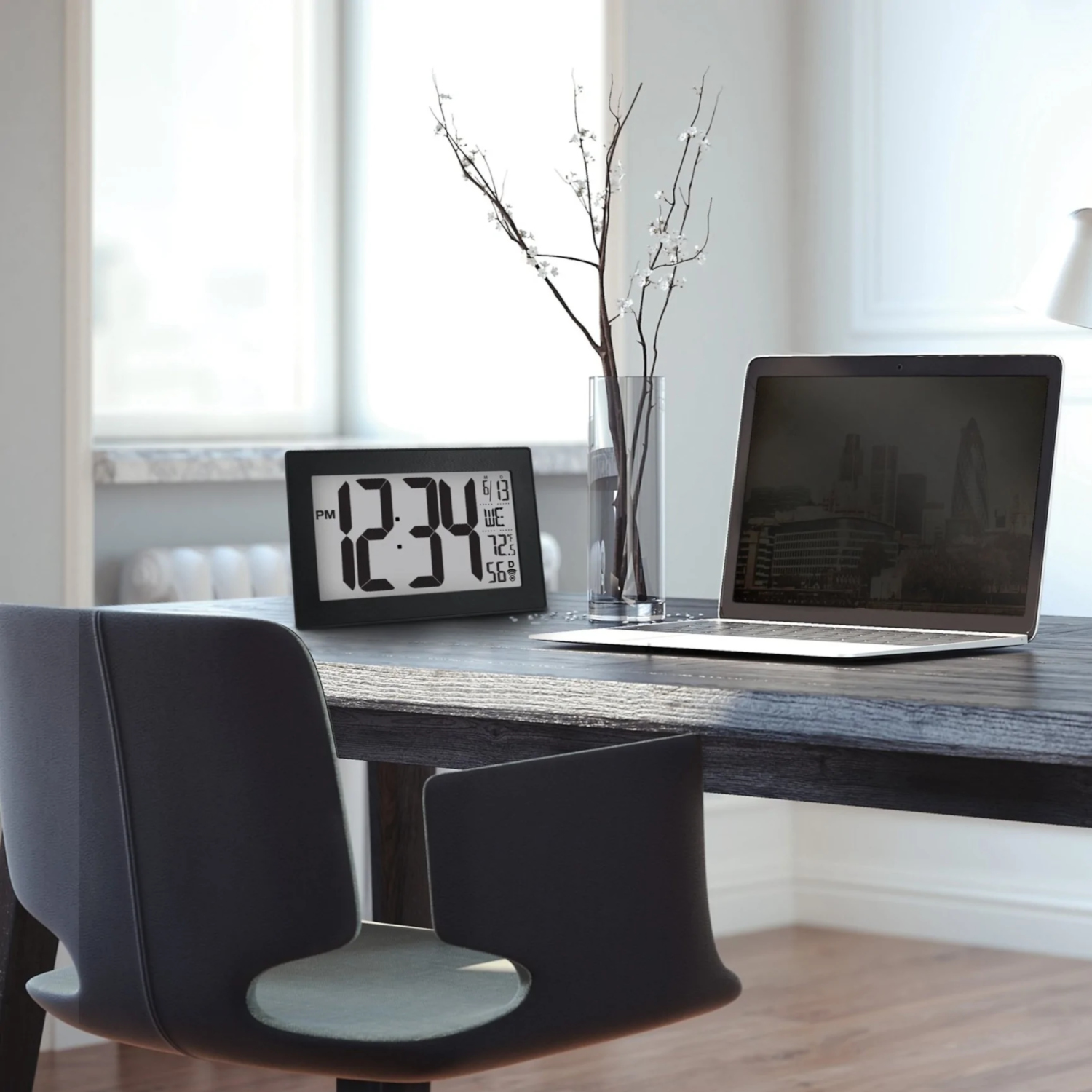 Bureau avec horloge, ordinateur portable et vase avec fleurs. Fenêtre en arrière-plan.