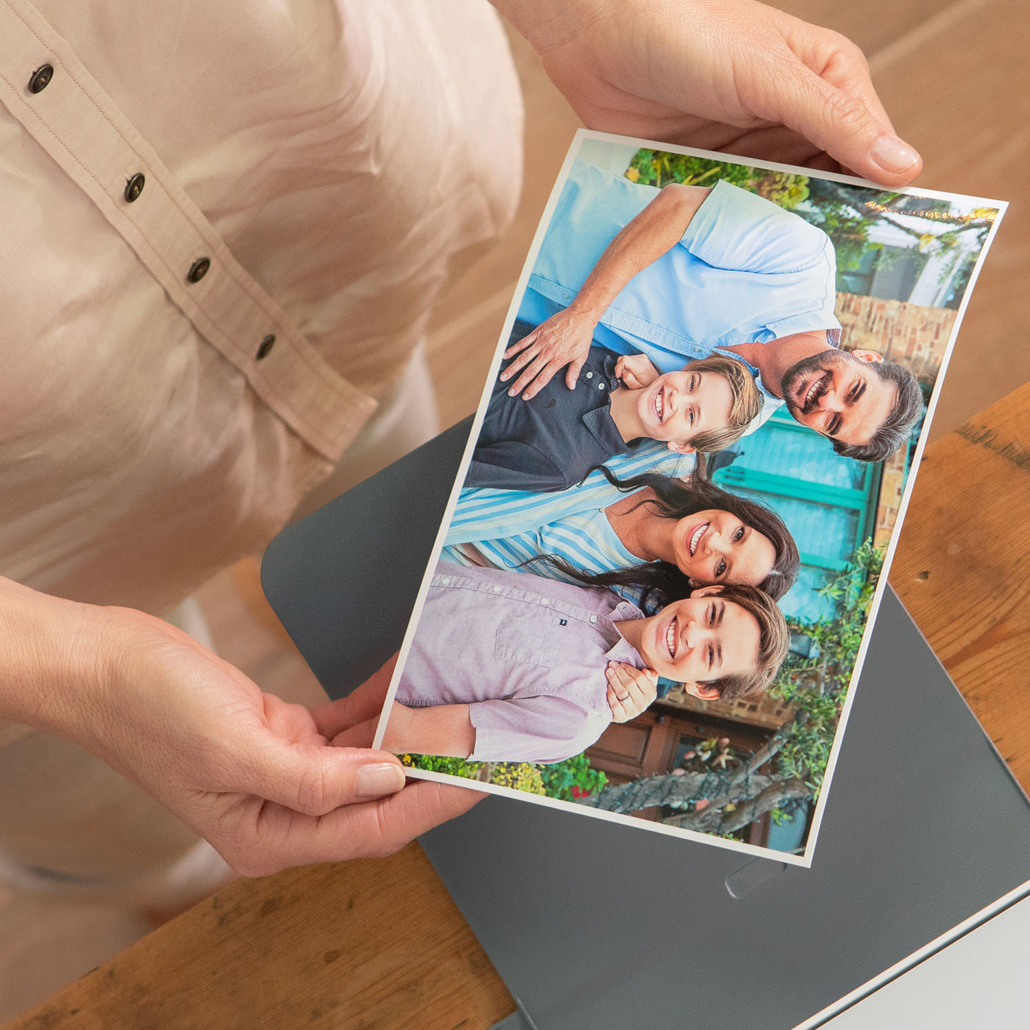 A person holding a family photo in their hands.