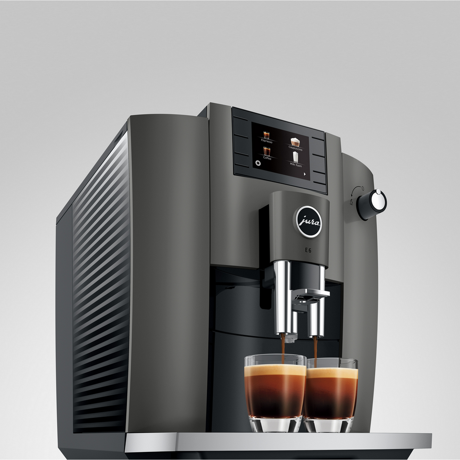 Een grijze Jura E6 koffiemachine met twee kopjes koffie die worden afgegeven.
