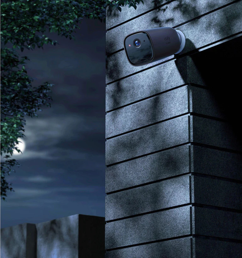 Caméra de sécurité sur un mur la nuit, sous un ciel éclairé par la lune. Caméra noire.