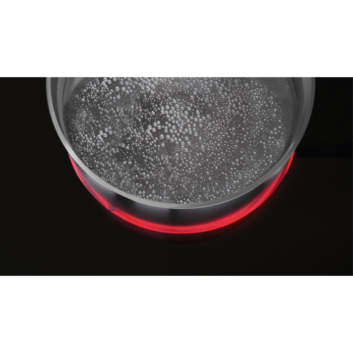 Agua hirviendo en una olla de vidrio sobre una estufa negra con un elemento calefactor rojo.