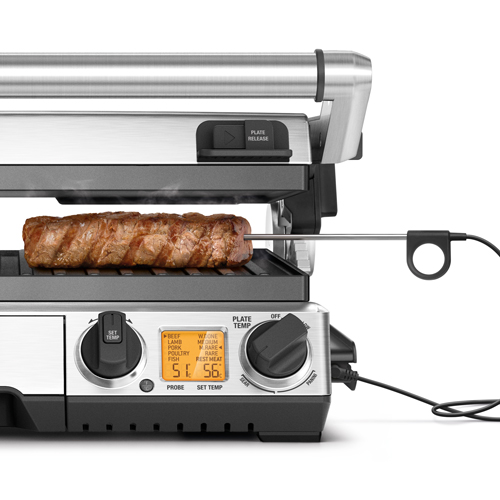 Grill with a steak cooking. Temperature controls and a probe are visible.