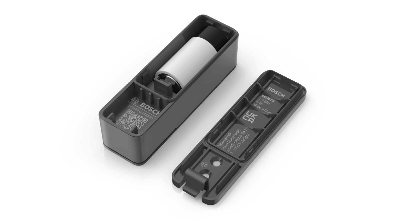 Geöffnetes schwarzes Kunststoffgerät mit einer weißen Zylinderbatterie im Inneren; anderes Teil daneben.