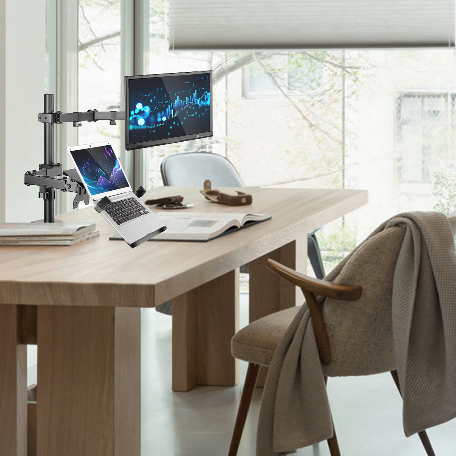 Office desk with laptop on a stand, monitor, and chair. Window in the background.