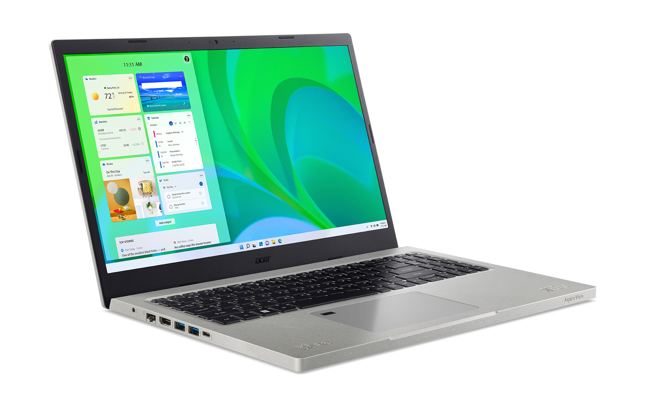 Portátil mostrando un escritorio Windows con widgets, sobre una superficie gris.