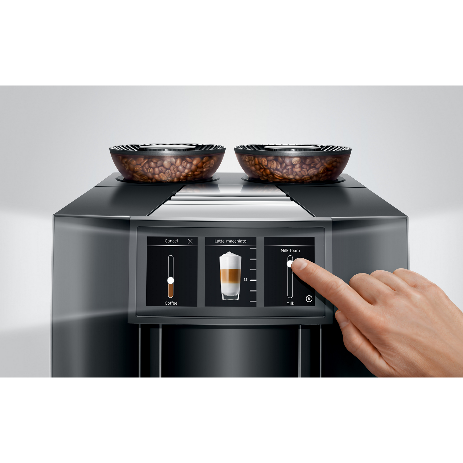 A close-up of a coffee machine with a hand touching the milk foam button on the screen.