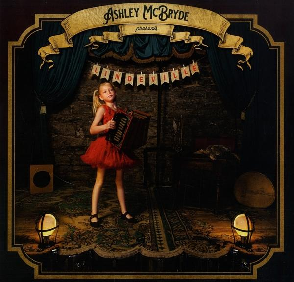Albumcover mit einem Mädchen in rotem Kleid, das auf einer Bühne Akkordeon spielt. Ein Banner liest 'Lindeville'.