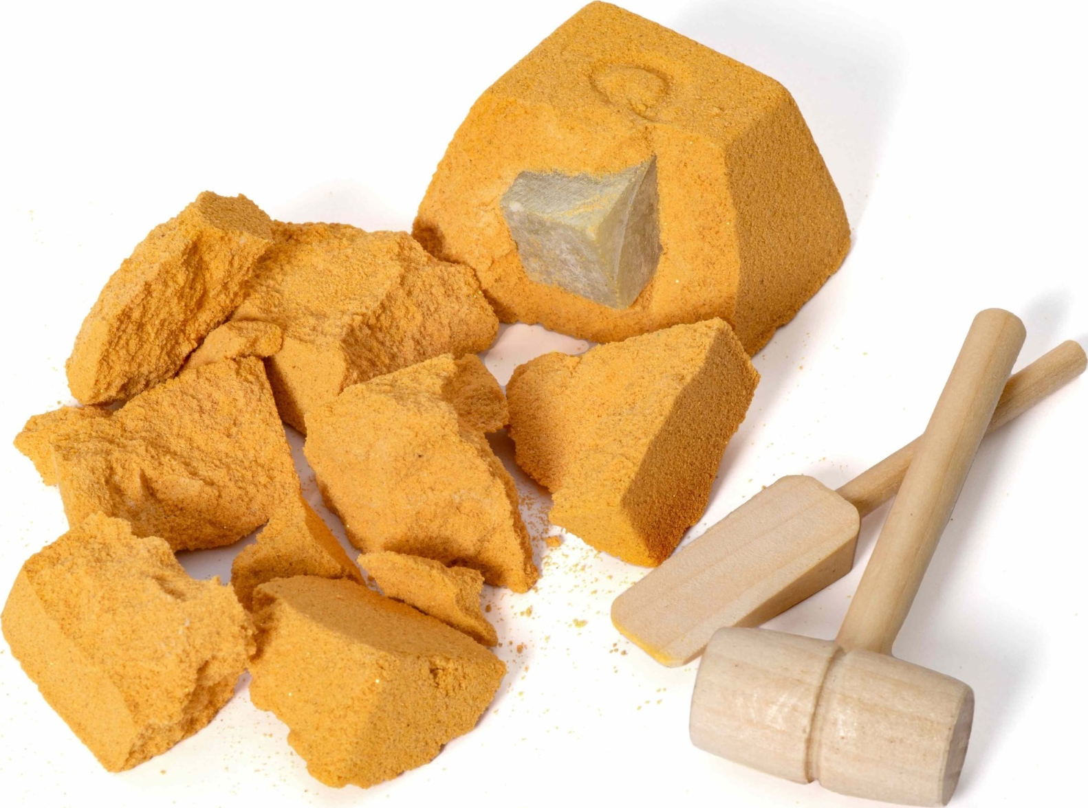 Ein hellorangefarbener Felsen, der zerbrochen wird, mit Stücken und kleinen Holzschlägeln.