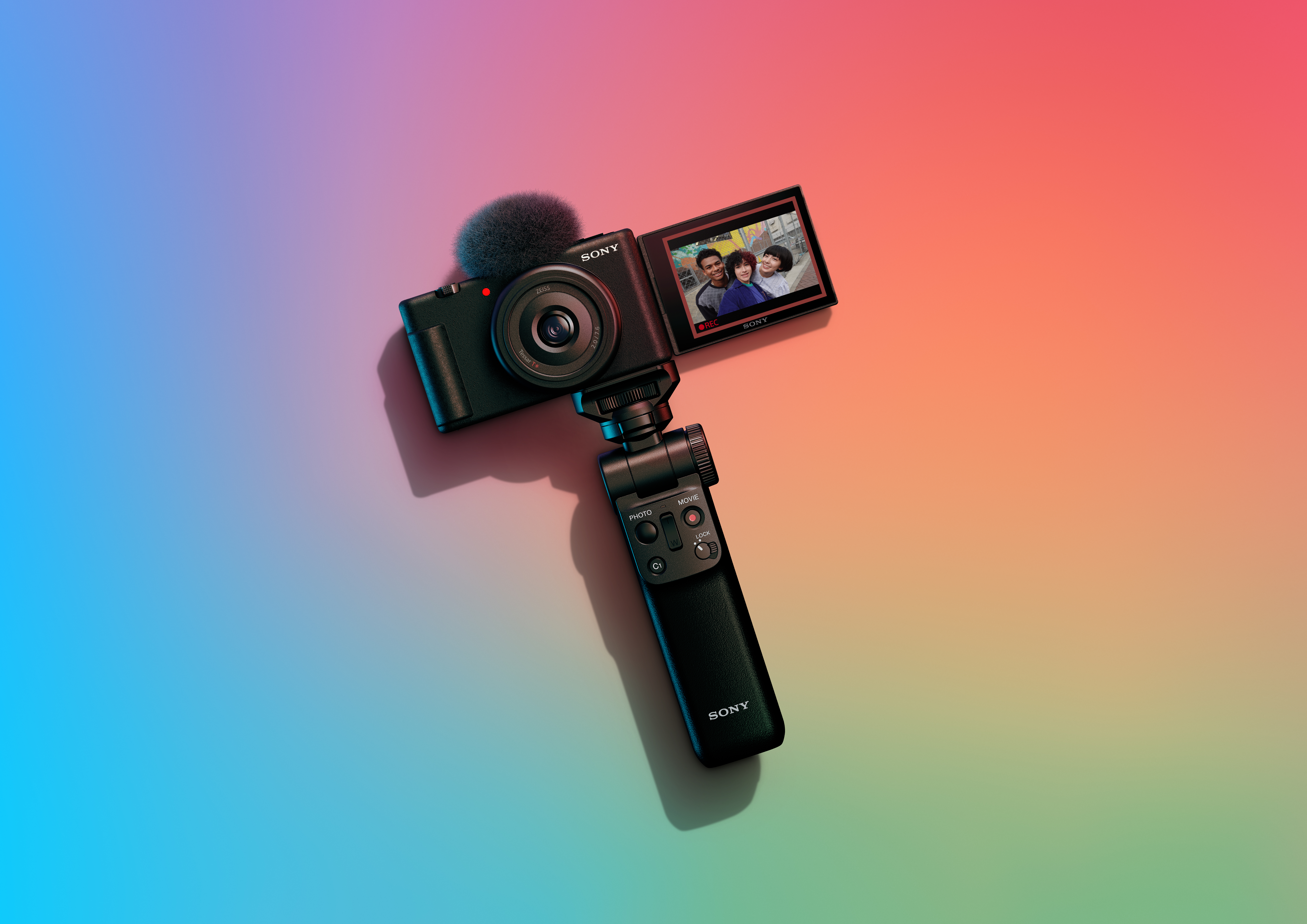 Schwarze Sony Vlog-Kamera auf Stativ, Bildschirm zeigt Selfie-Video, bunter Farbverlaufshintergrund.
