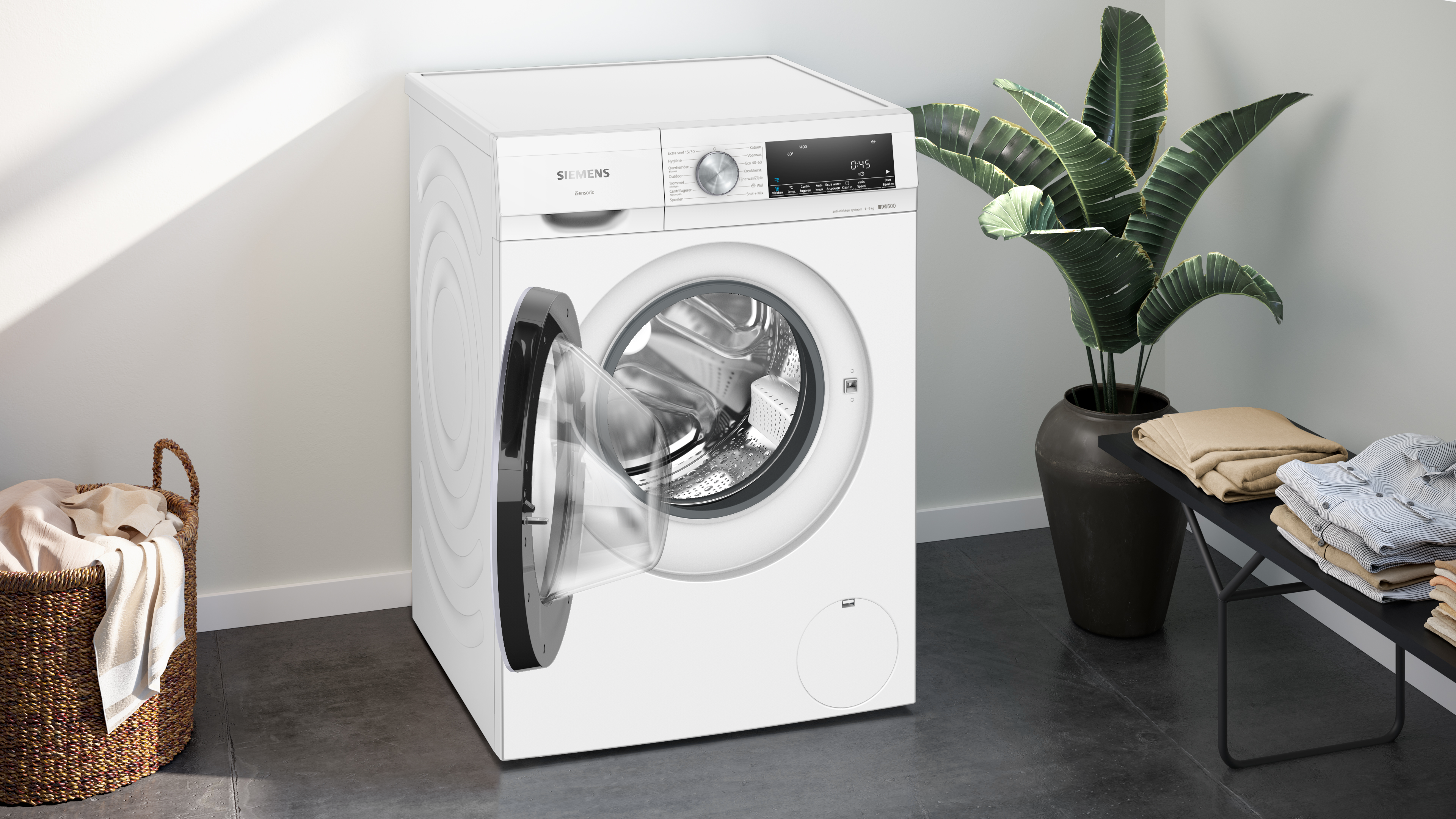 A white washing machine with an open door stands next to a laundry basket.