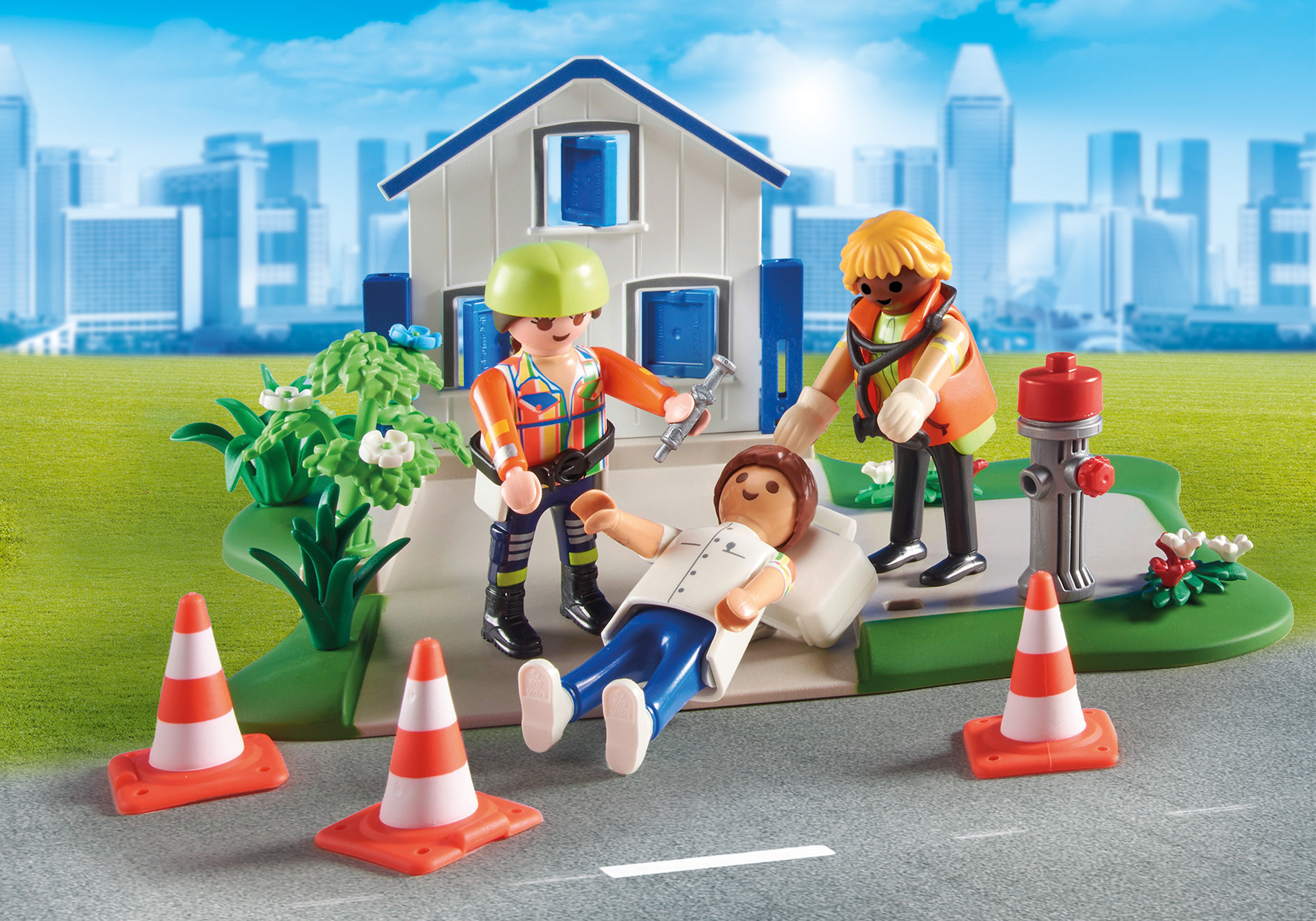 Playmobil-Szene: 3 Figuren um einen Patienten. Absperrkegel und ein Haus im Hintergrund.