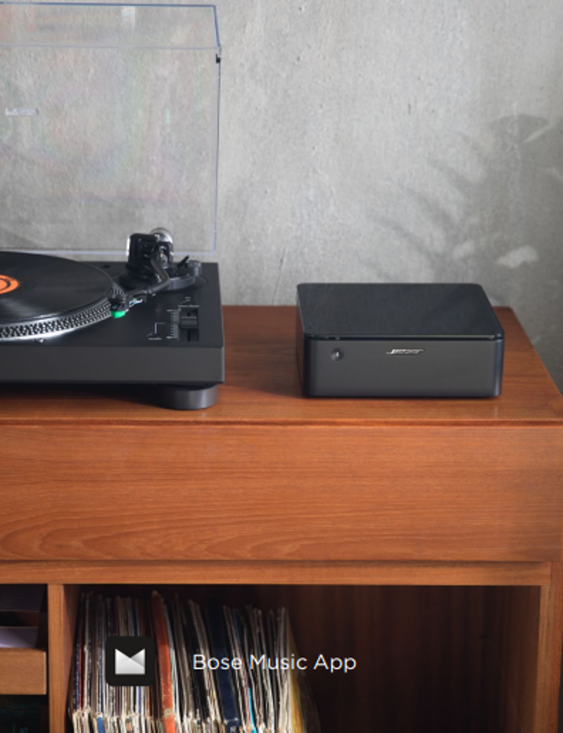 Platine vinyle, haut-parleur noir et étagère avec disques vinyles.