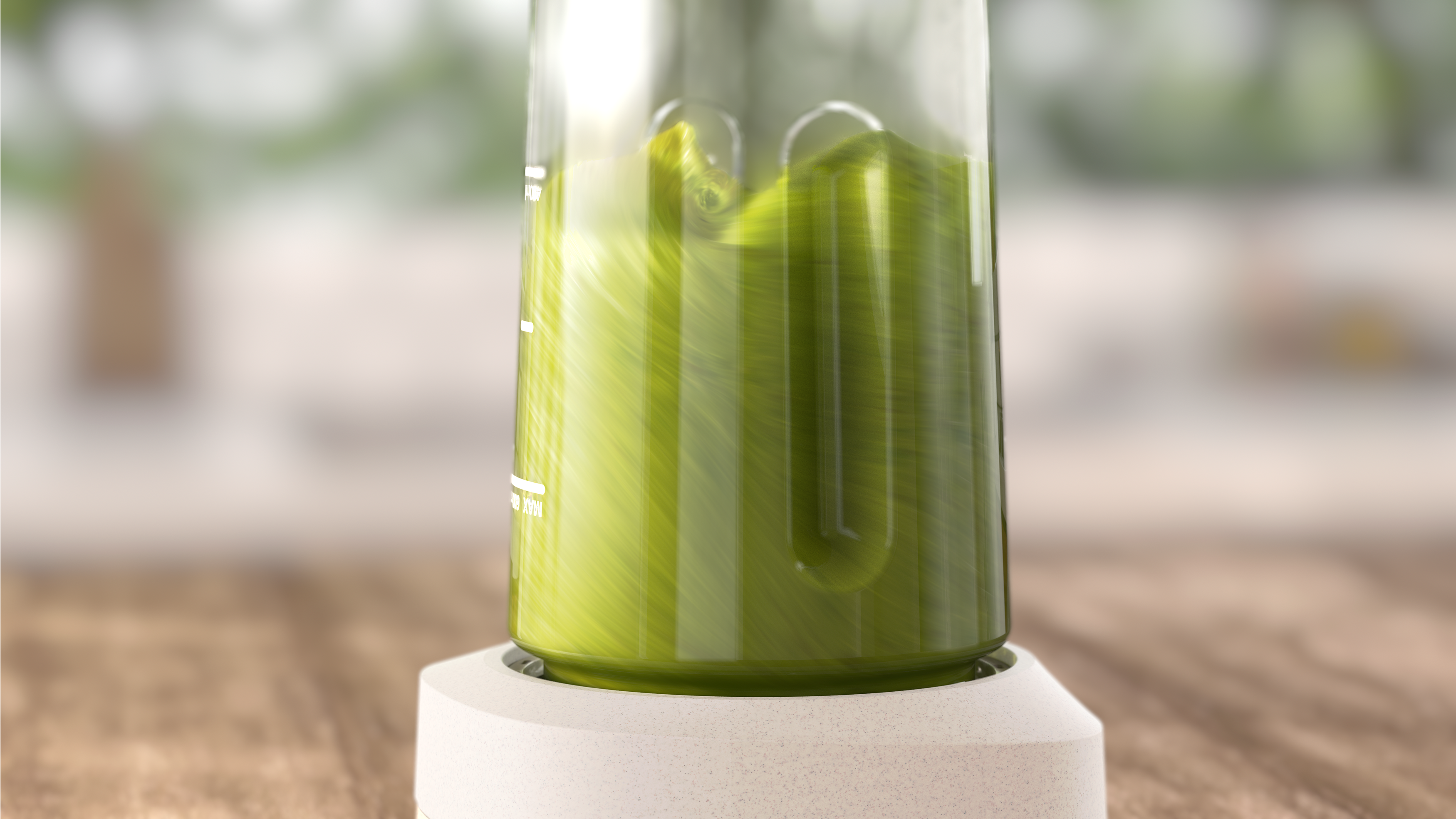 Un vaso de licuadora transparente lleno de líquido verde, sobre una base blanca, vista de cerca.