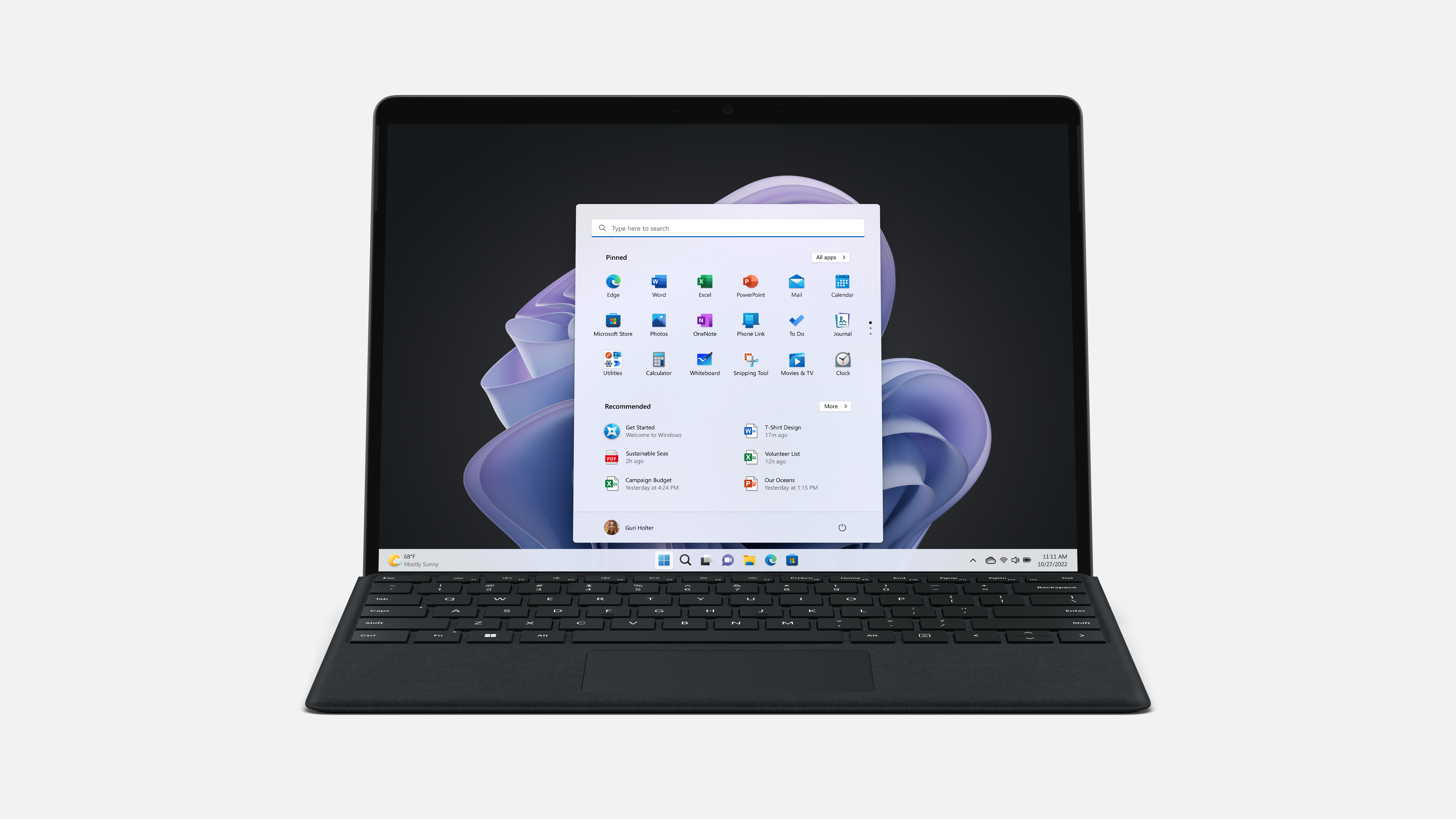 Laptop mit Windows 11, Startmenü. Im Hintergrund ein lila abstraktes Design.