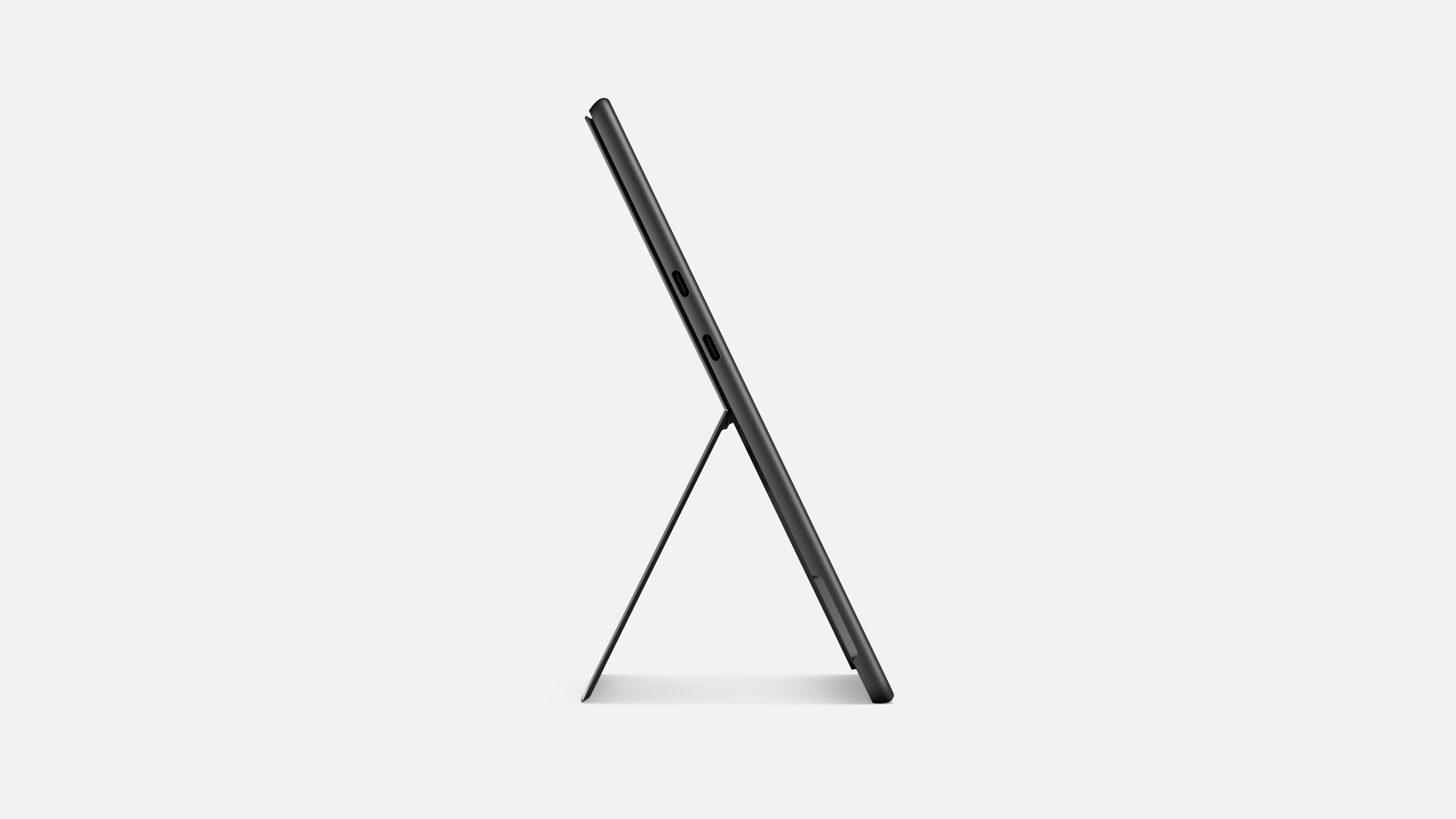 Ein schwarzes Tablet, das von einem Ständer gehalten wird, von der Seite auf weißem Hintergrund betrachtet.