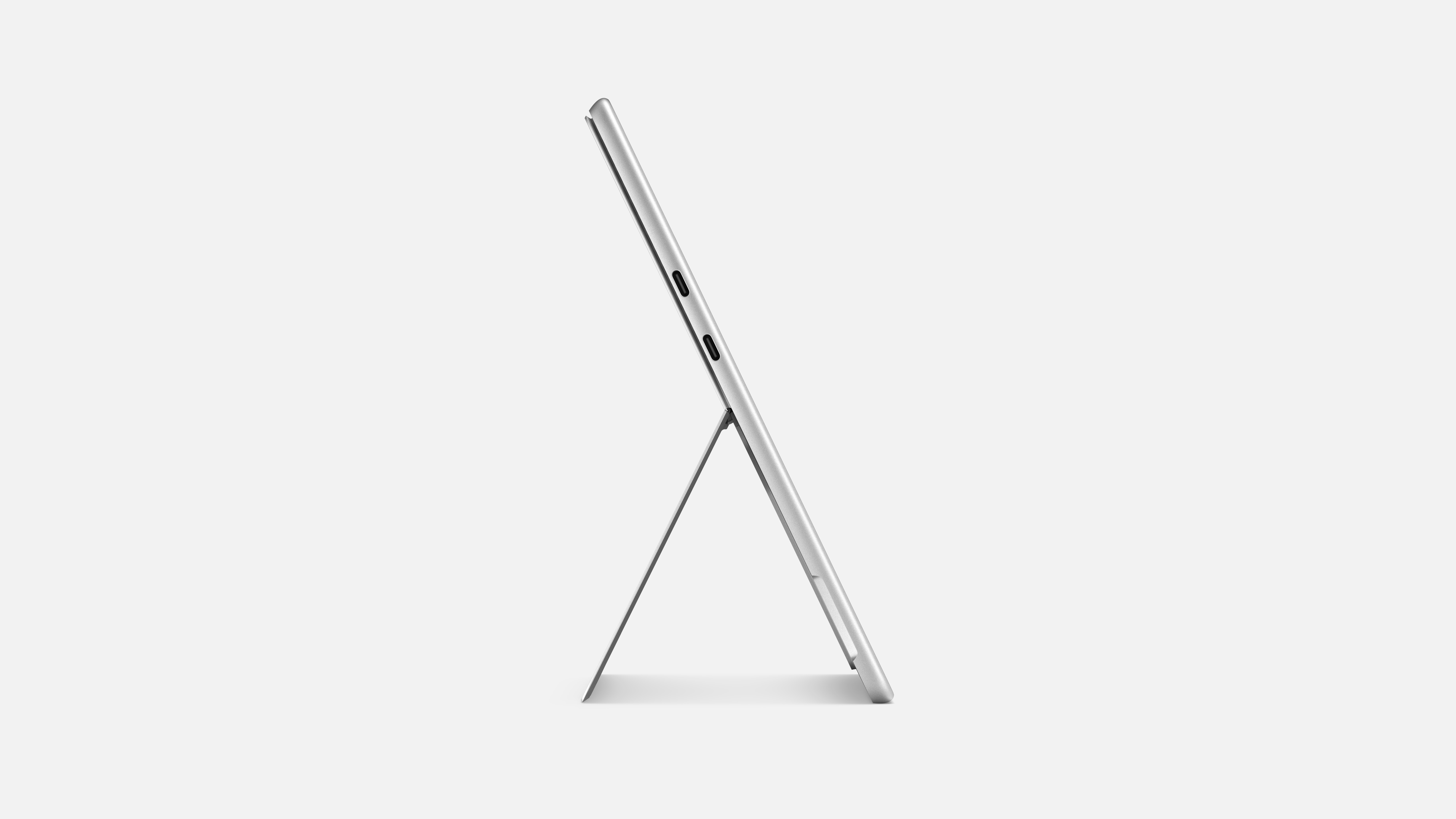 Ein silbernes Tablet ist mit einem Ständer aufgestellt und zeigt ein Seitenprofil vor weißem Hintergrund.