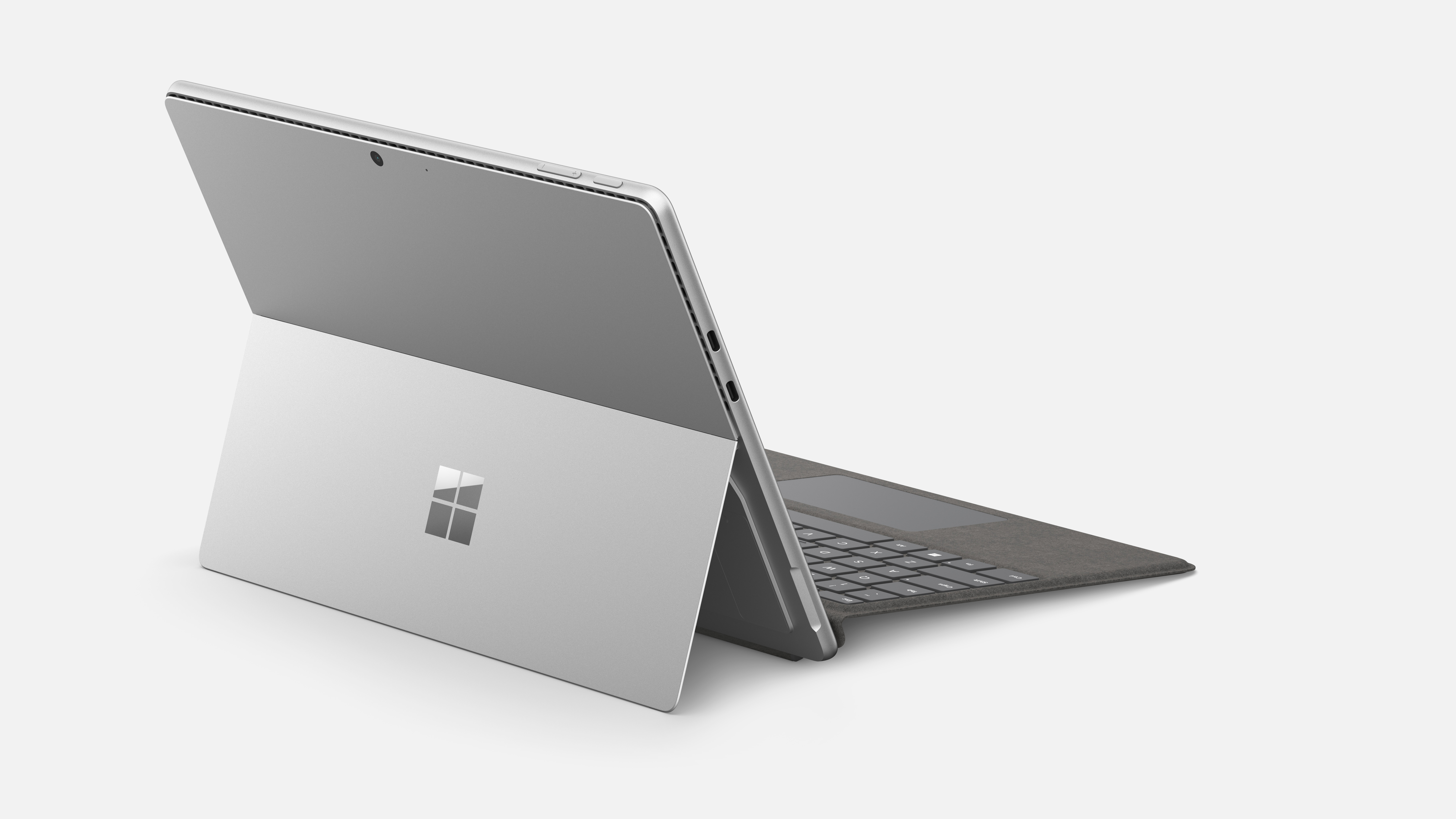 Ein silbernes Tablet mit Tastatur und Ständer, das das Microsoft-Logo zeigt.