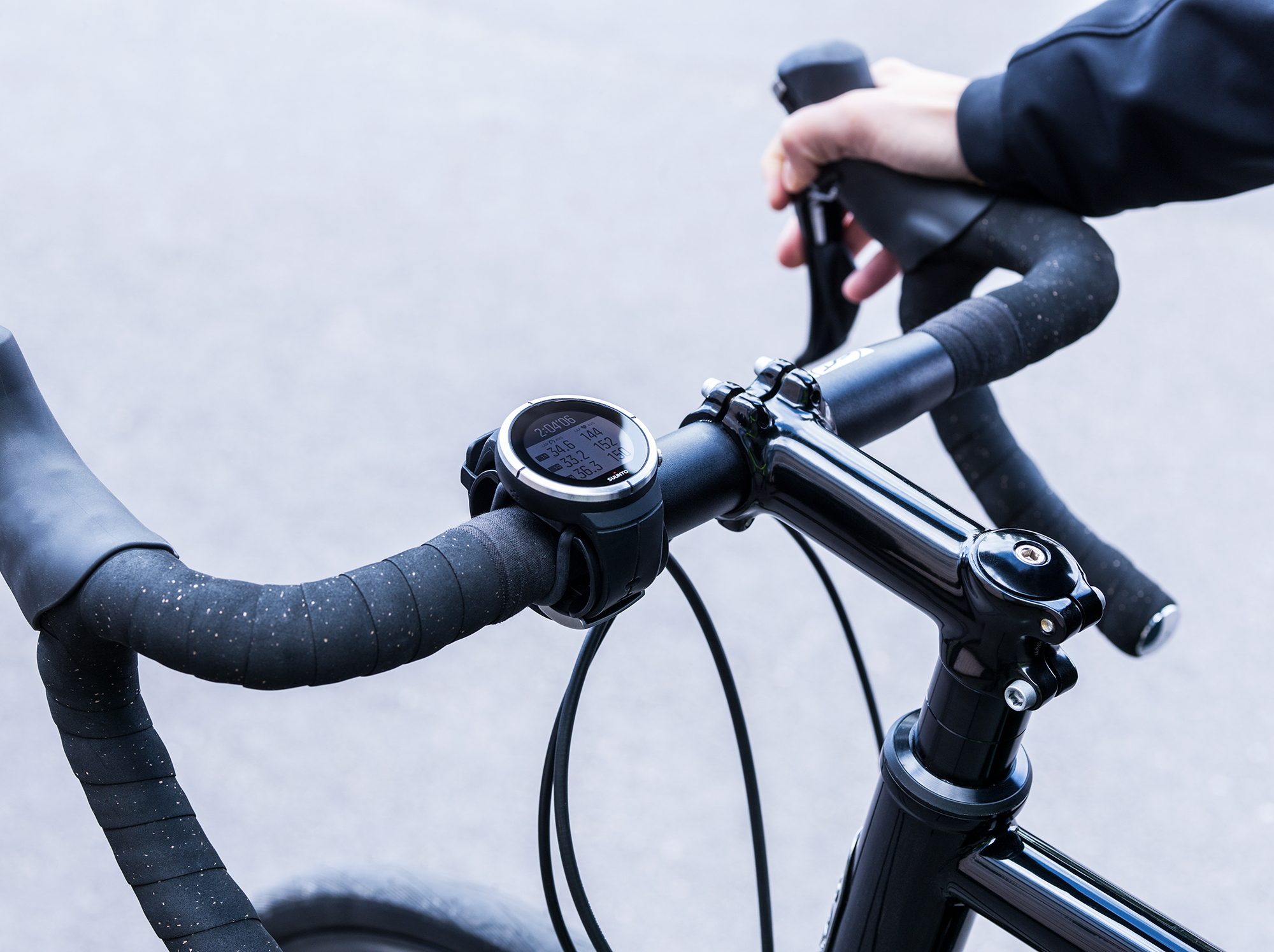 Hände des Radfahrers am Lenker, Anzeige von Geschwindigkeit, Distanz und Zeit.