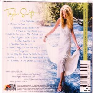 Taylor Swift CD hátlapja, rajta egy fotó róla fehér ruhában a víz közelében.