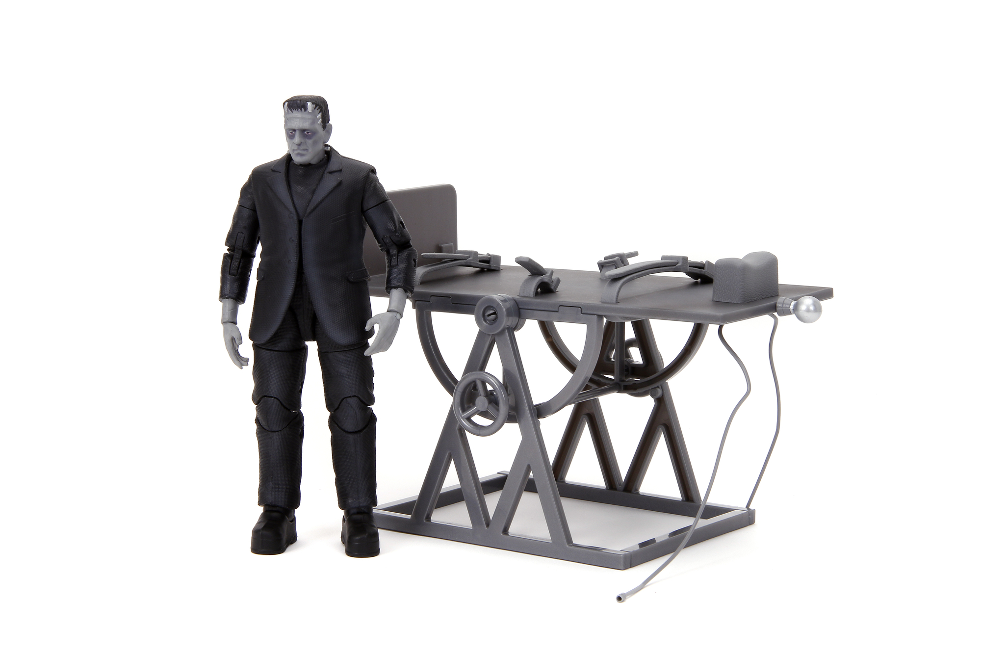 Frankenstein-Figur steht neben einem grauen Operationstisch mit Werkzeugen darauf.