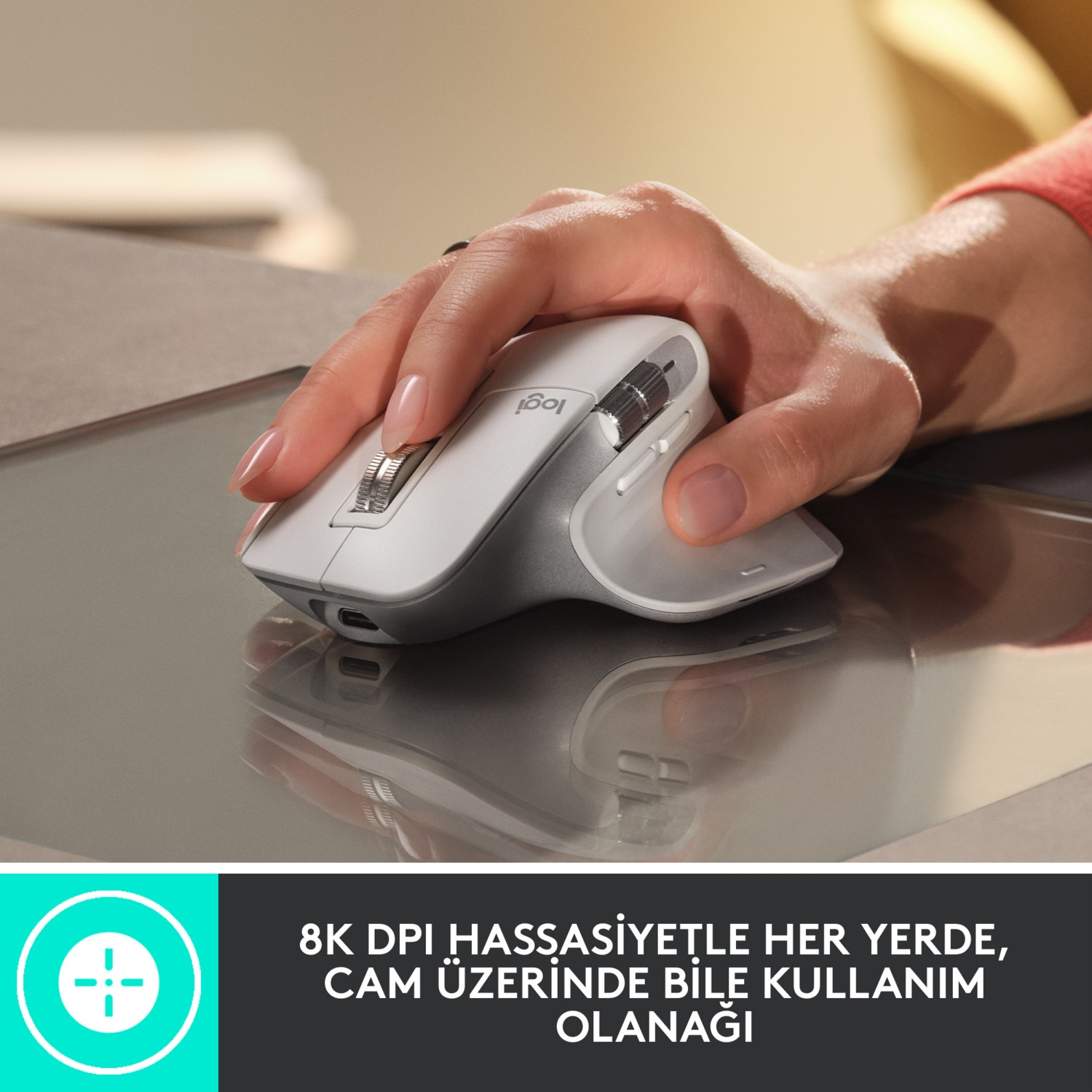 Yansıtıcı bir yüzey üzerinde beyaz ve gri bir fare kullanan bir kişi.