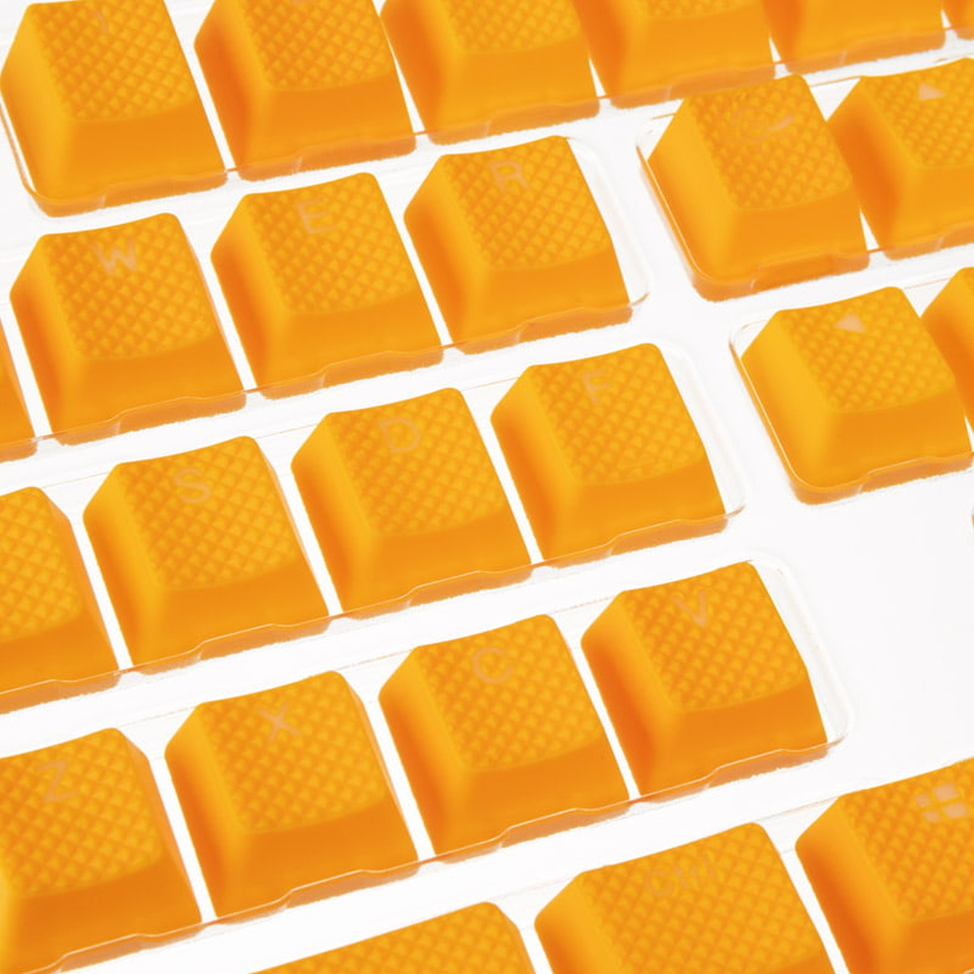 Nahaufnahme von orangefarbenen Tastaturtasten, in Reihen angeordnet, mit weißen Buchstaben.