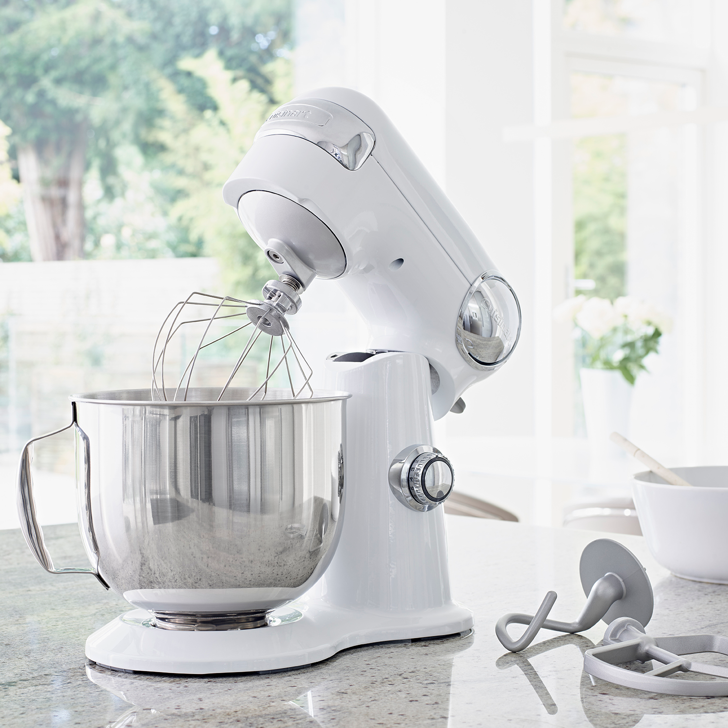 Robot culinaire blanc avec un bol en acier inoxydable et accessoires. Plan de travail de cuisine.