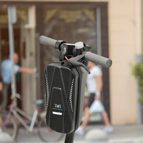 Manubrio di scooter elettrico nero con borsa nera e sfondo sfocato di strada.