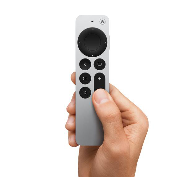 Eine Hand hält eine silberne Apple TV Fernbedienung mit Knöpfen.