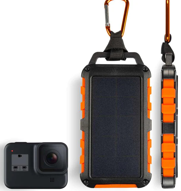 Een zwarte GoPro-camera en een oplader op zonne-energie. Oranje en zwart. Karabijnhaak.