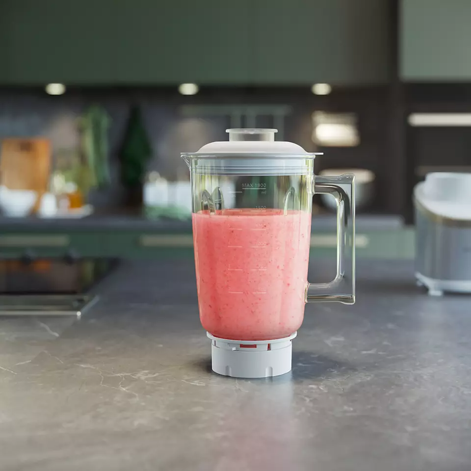 Turmixgép rózsaszín folyadékkal. A turmixgép egy konyhai pulton van. Zöld háttér.