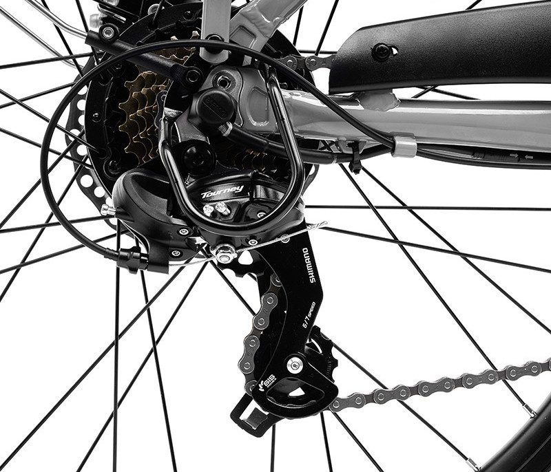 Close-up van de achterderailleur en versnellingen van een fiets, met de ketting en spaken zichtbaar.