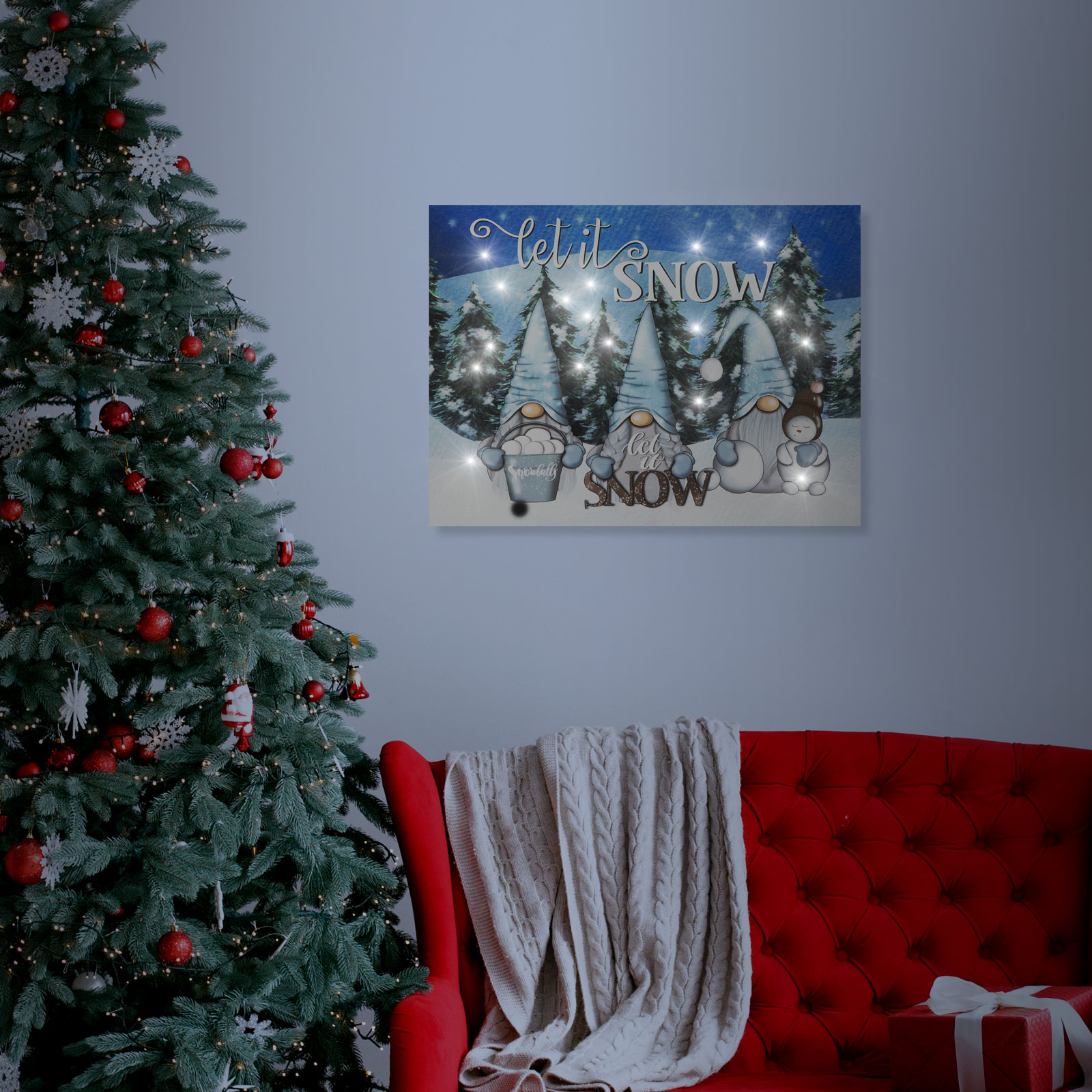 Karácsonyfa és piros kanapé, világító 'Let it snow' felirattal és hóemberekkel.