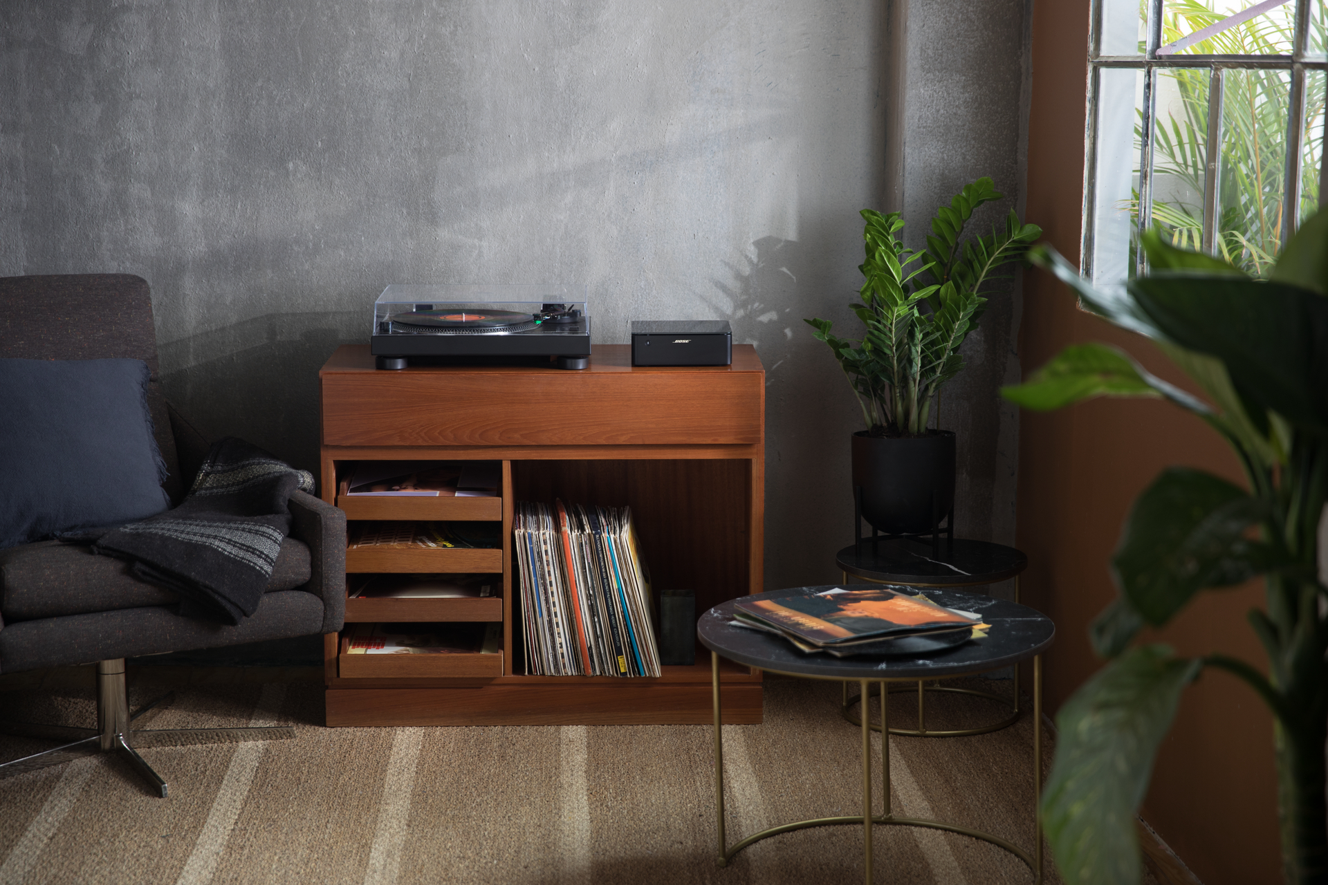 Wohnzimmer mit Plattenspieler, Schallplatten und Pflanzen.