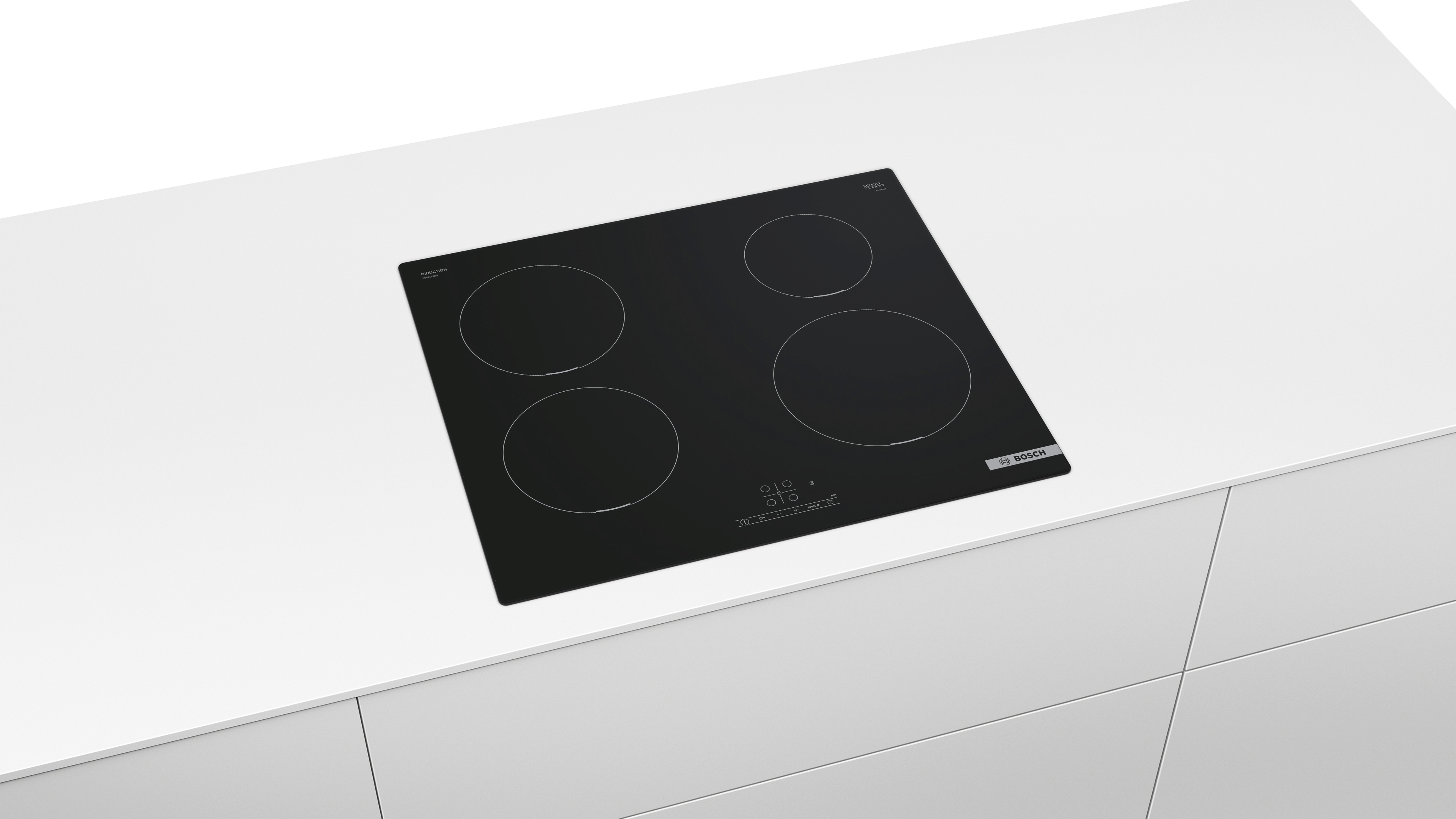 Black induction cooktop with four burners on a white counter. Bosch logo is on the right side.