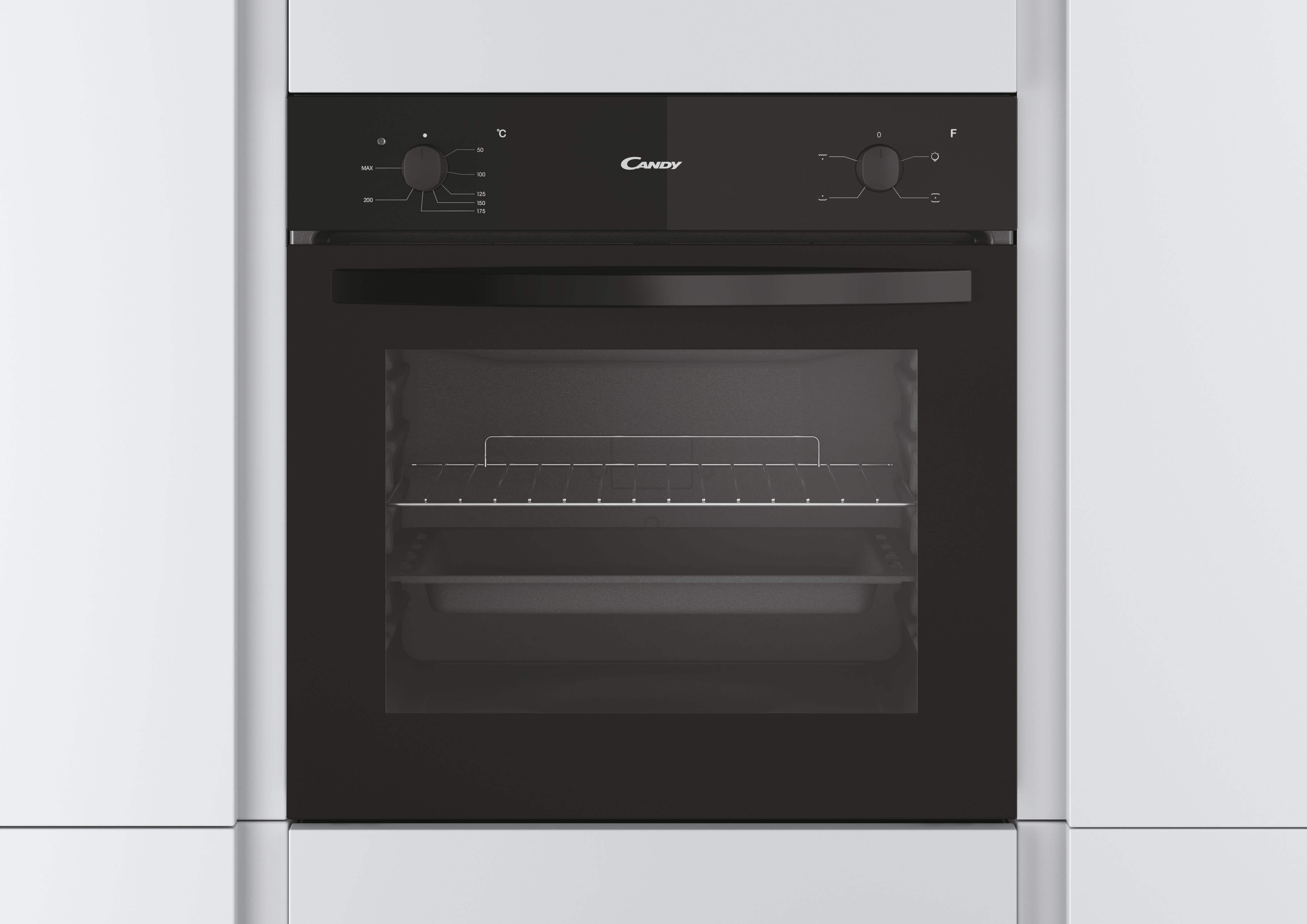 Horno Candy negro empotrado en gabinetes blancos. Puerta del horno cerrada. Perillas visibles.