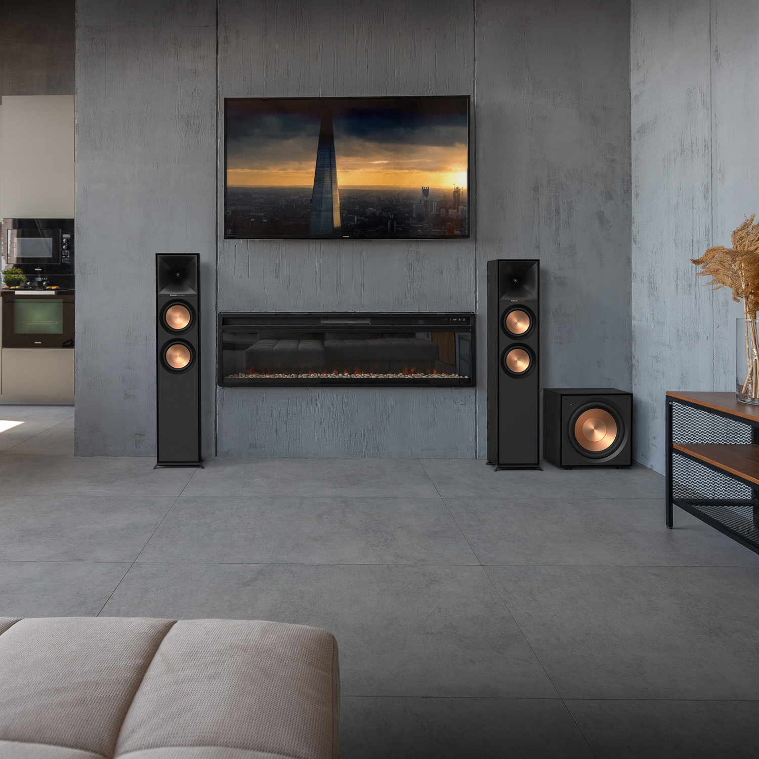 Living room with TV, speakers, and a fireplace.