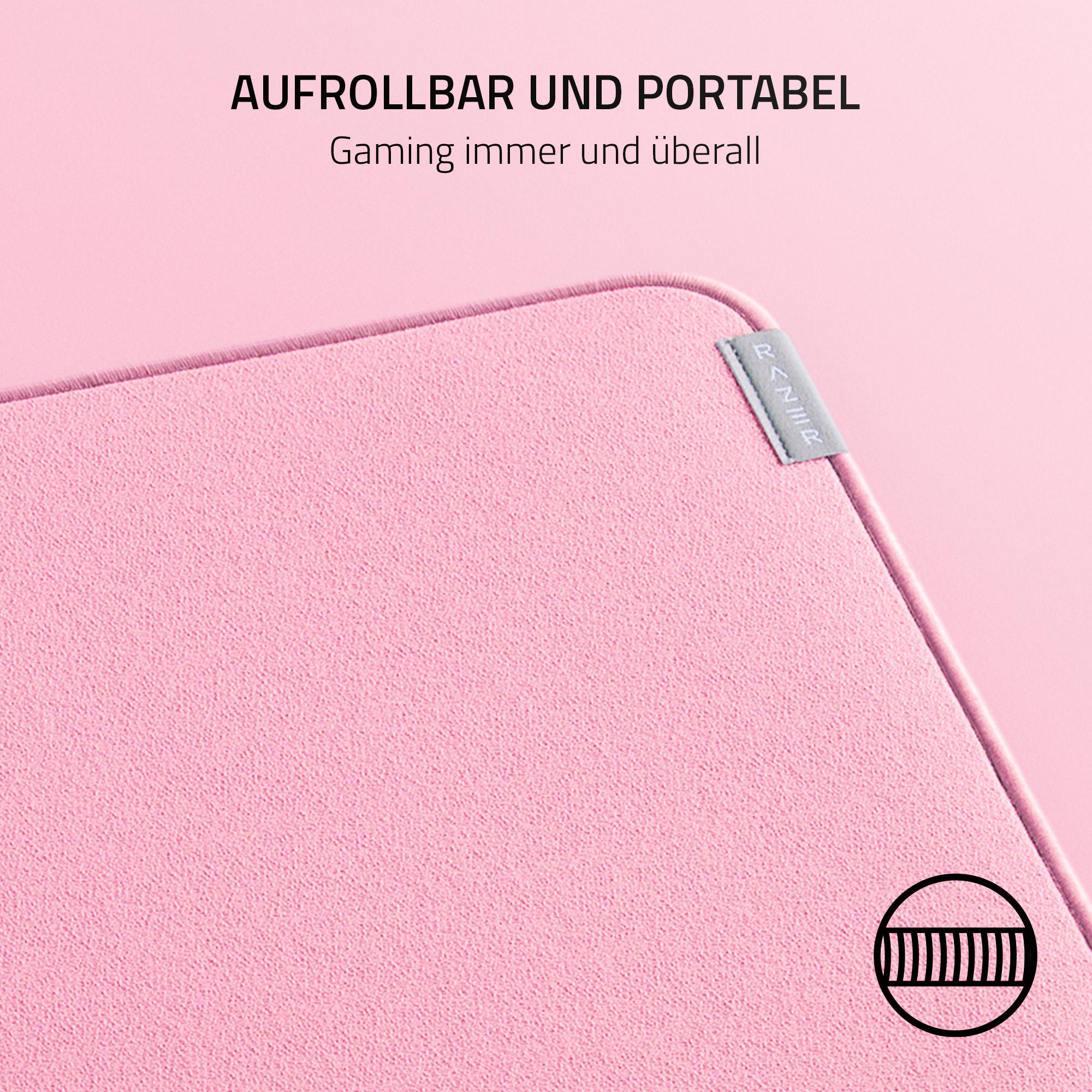 Rosa Gaming-Mauspad. Text lautet 'Aufrollbar und Portable' und 'Gaming immer und überall'. Schwarzes Logo unten rechts.