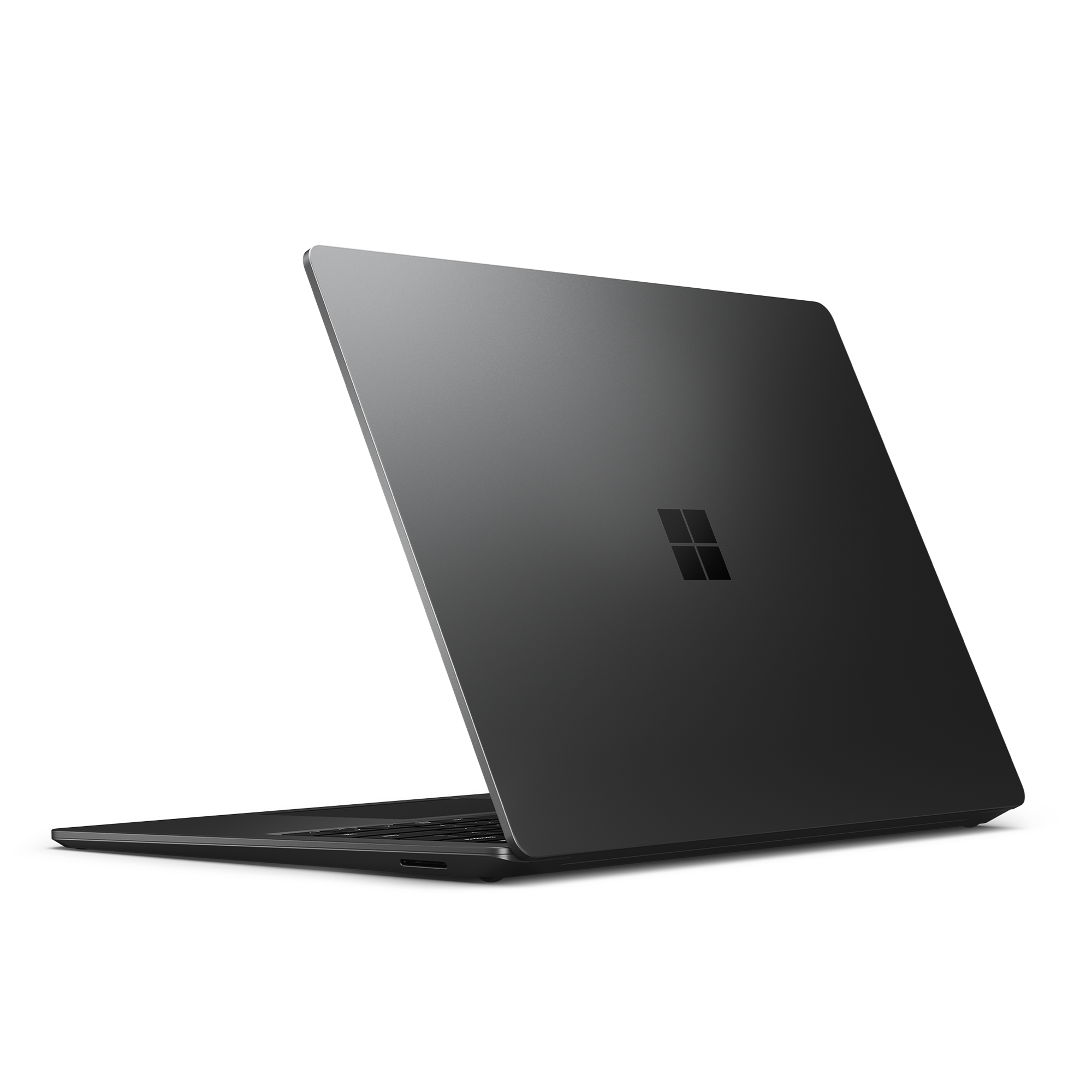 Un portátil negro con el logo de Microsoft en la parte trasera está ligeramente inclinado.