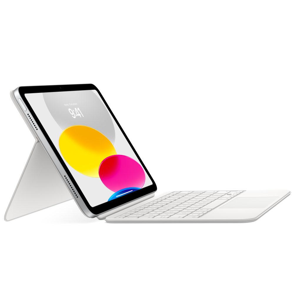 Tableta apoyada en soporte con teclado. Formas amarillas y rosas en pantalla. Fondo blanco.