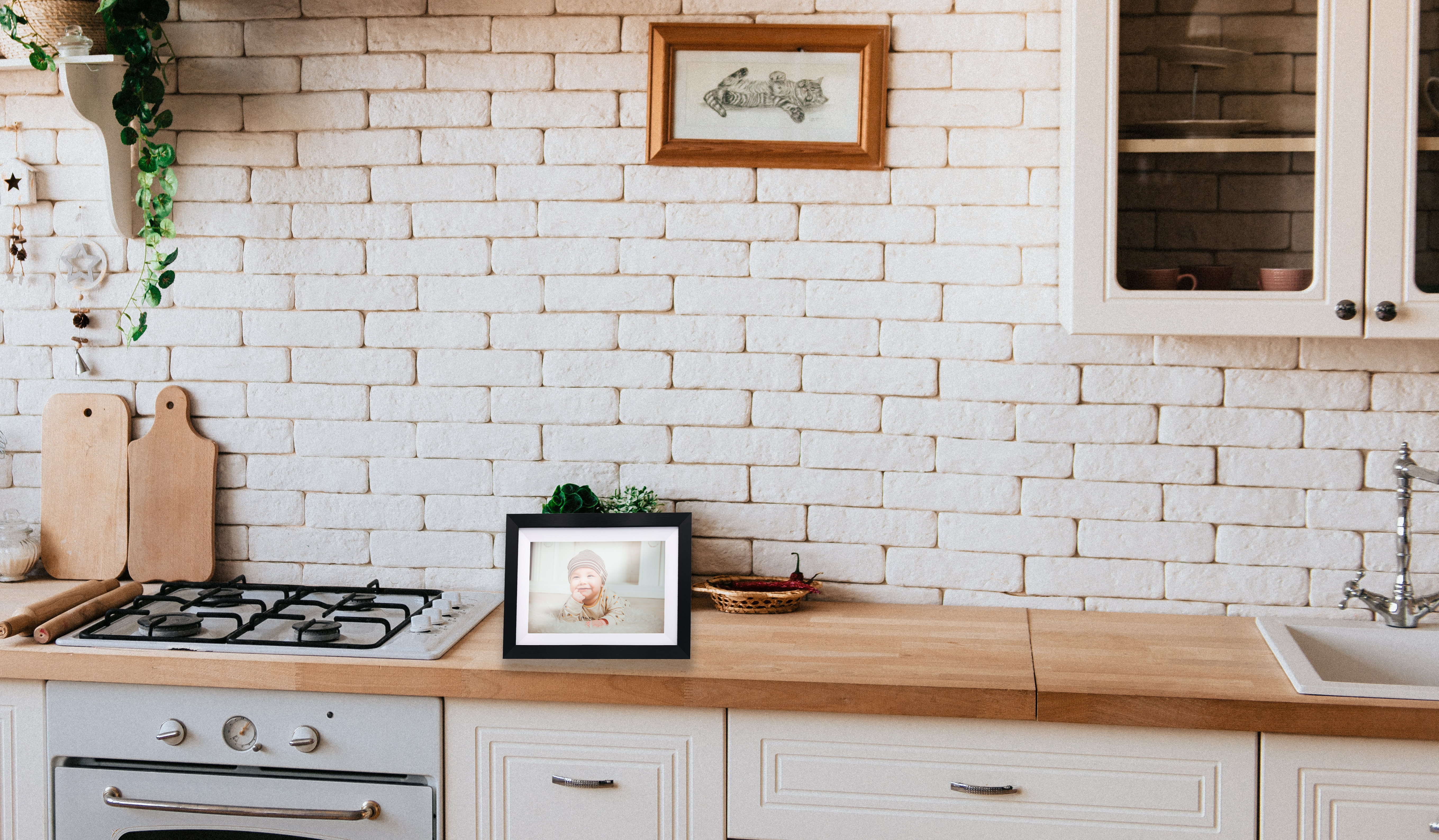Un comptoir de cuisine avec une photo encadrée, une cuisinière et un mur de briques blanches en arrière-plan.