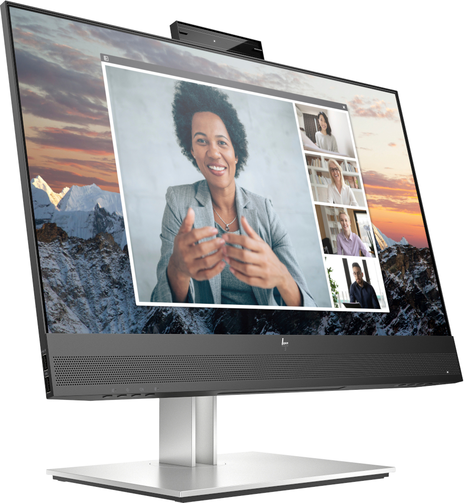 Computer monitor with a video conference on screen. It is on a white desk.