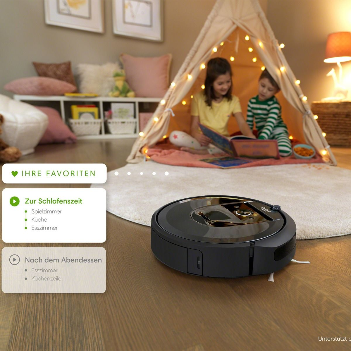 Ein Roboter-Staubsauger auf Holzboden. Zwei Kinder lesen in einem Zelt.