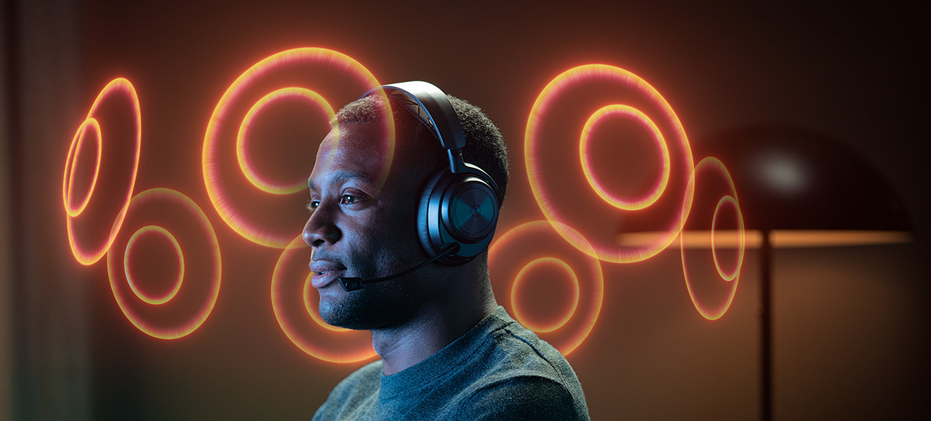 A man wearing a headset, with orange glowing circles around his head.