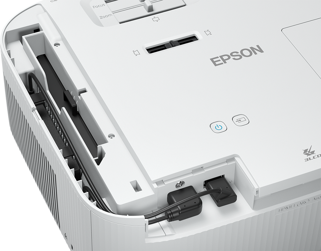 Ein weißer Projektor mit Ein-Aus-Taste und Kabelanschlüssen. Epson steht auf der Seite.