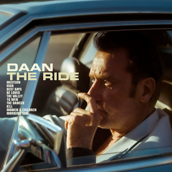 Een man in een auto, uit het raam kijkend, met de tekst 'DAAN THE RIDE'.