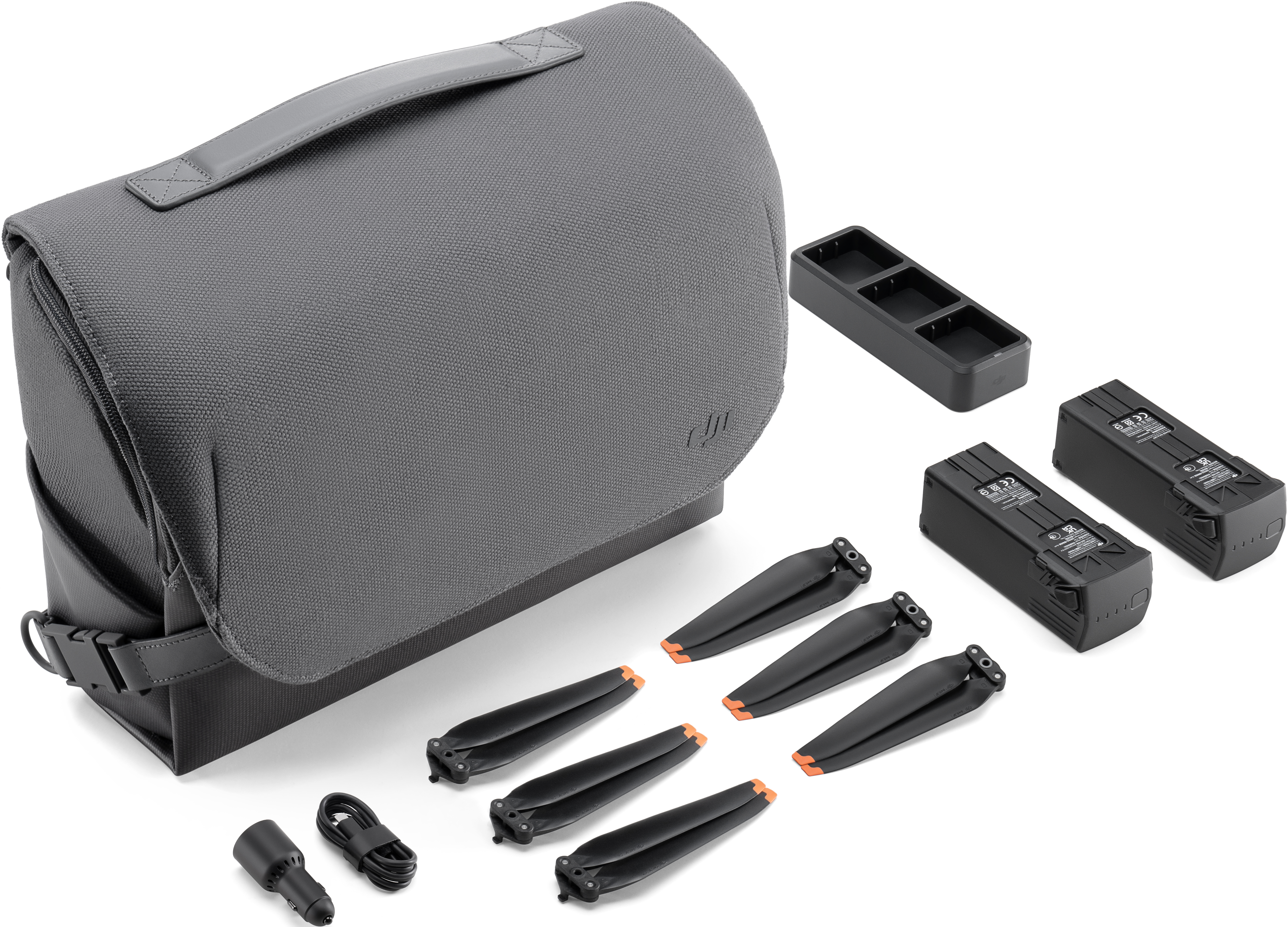 Drohnenzubehör: eine Tasche, Akkus, Propeller, ein Ladegerät und Kabel. Weißer Hintergrund.