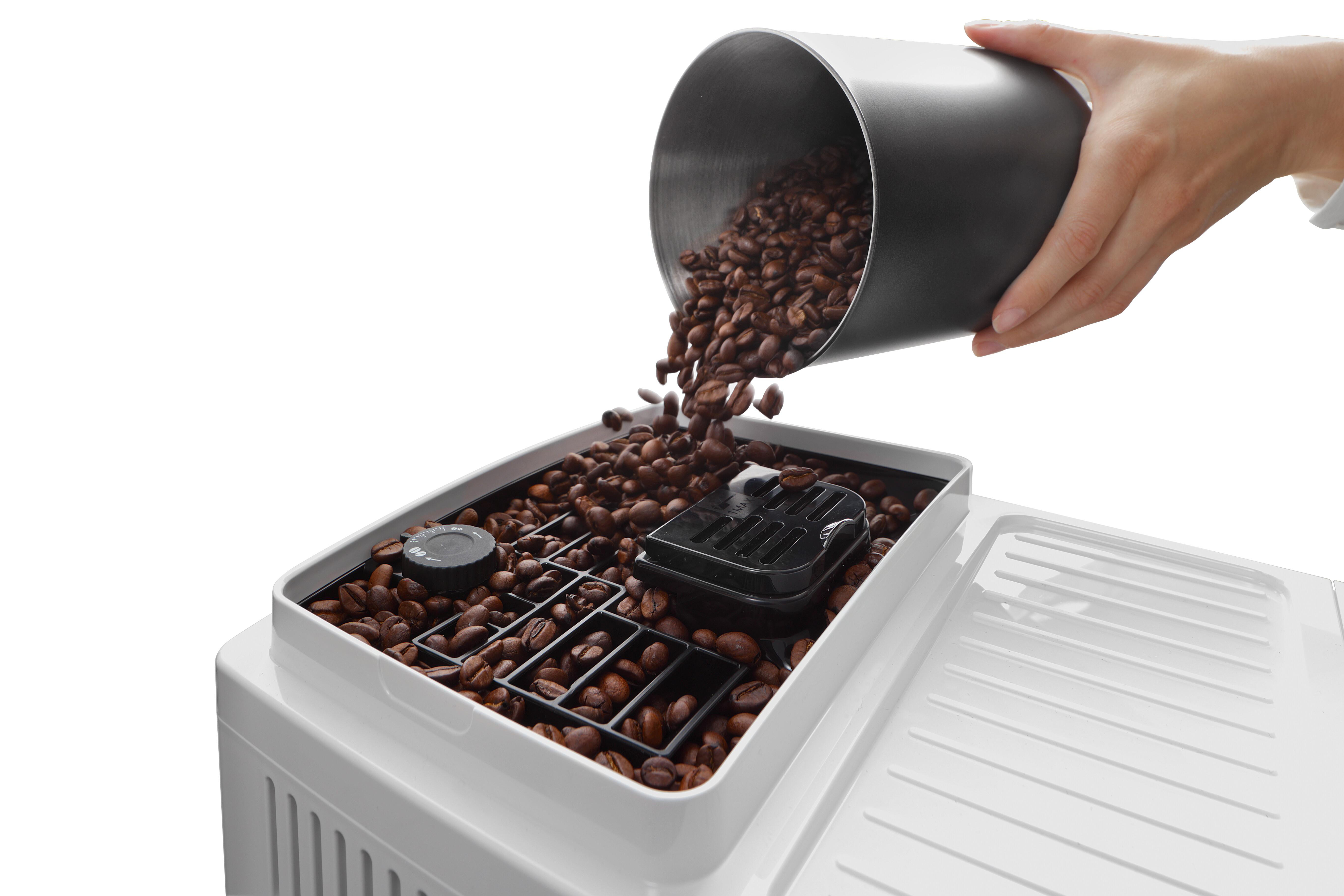 Eine Hand schüttet Kaffeebohnen aus einem schwarzen Behälter in eine Kaffeemaschine.