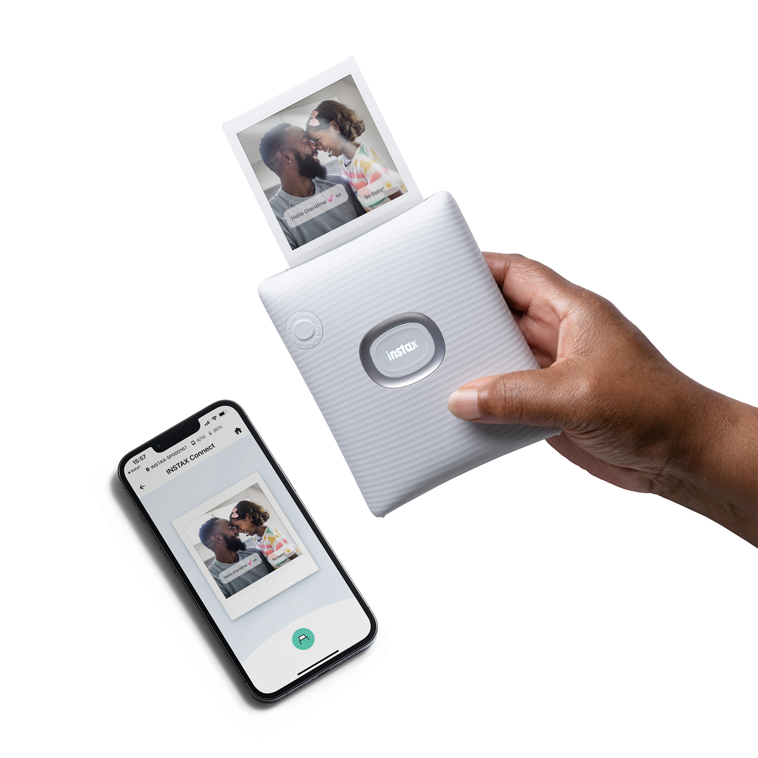 Una persona che tiene una fotocamera istantanea bianca che stampa una foto. Un telefono è accanto.
