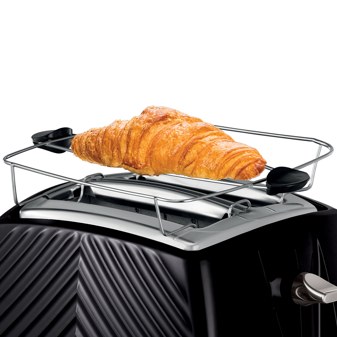 Egy croissant egy fém rácson egy fekete kenyérpirítóban, fehér háttér előtt.